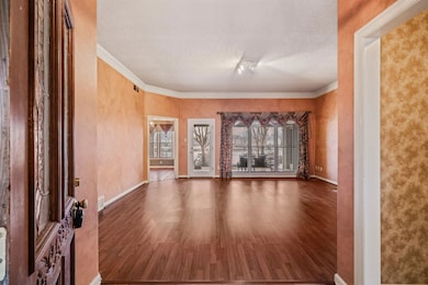 Unfurnished living room featuring crown molding, a
