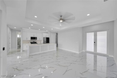Unfurnished living room with a tray ceiling, reces