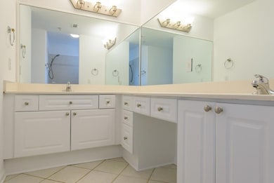 Full bath featuring light tile patterned flooring and double vanity