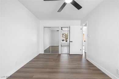 Unfurnished bedroom with baseboards, dark wood fin