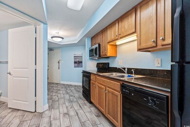 Kitchen with light wood-type flooring, a textured 