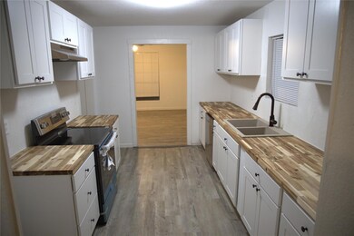 Kitchen with under cabinet range hood, light wood-