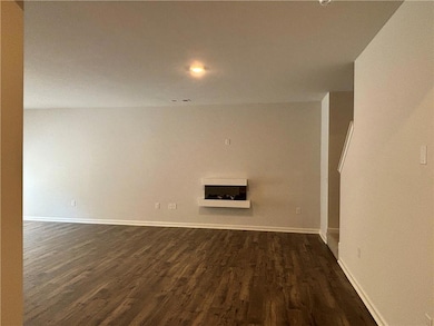 Unfurnished room with dark wood-style floors, recessed lighting, and a fireplace
