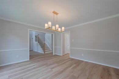 Formal dining room features new flooring an a stri