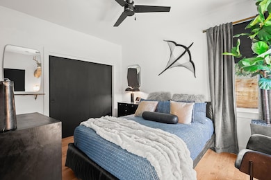Bedroom with wood finished floors, a closet, and 