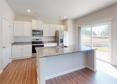 Kitchen featuring white cabinetry, stainless steel