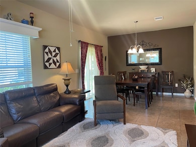 Living area featuring baseboards, light tile patt