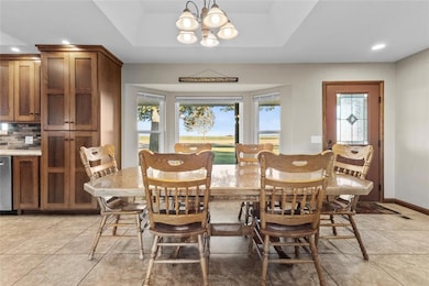 Tiled dining area with a tray ceiling and an invit
