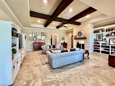 Living area featuring beamed ceiling, arched walkw