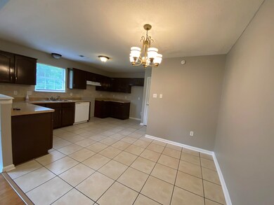 Kitchen with dark brown cabinets, sink, white dish