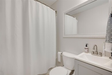 Full bathroom with toilet, vanity, and a shower w