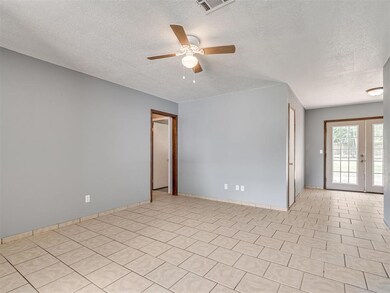 Unfurnished room featuring ceiling fan, a textured ceiling, and light tile floors