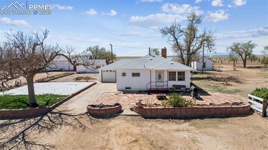 Rear view of property with an attached garage, roo