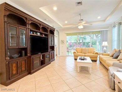 Living room featuring a tray ceiling, recessed lig