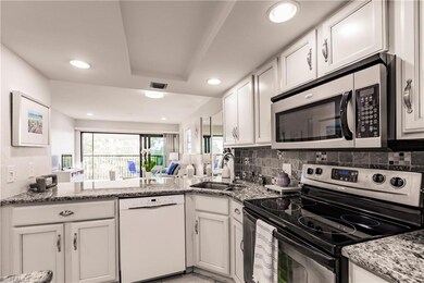 Kitchen with white cabinets, backsplash, stainless
