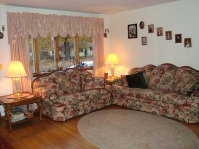 Living Room show large window and hardwood floorse