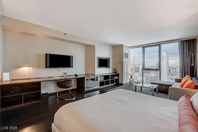 Bedroom featuring wood finished floors, a wall of