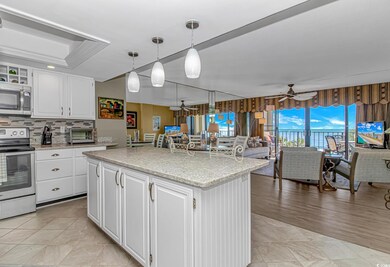 Kitchen with white cabinets, stainless steel appliances, open floor plan, and ceiling fan