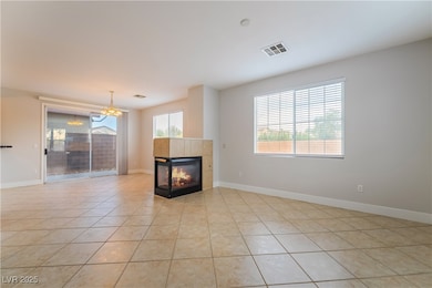 Unfurnished living room featuring light tile patterned floors, a tile fireplace, and a chandelier