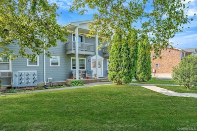 Traditional-style home with a balcony and a front yard
