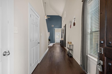Corridor featuring baseboards, dark wood-style fl