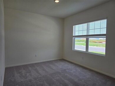 Empty room featuring dark colored carpet, baseboa