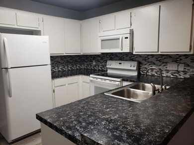 Kitchen featuring white appliances, backsplash, w