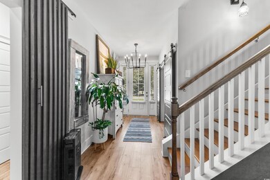 Foyer entrance featuring stairs, a barn door, ligh