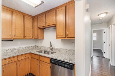 Kitchen with dishwasher, a sink, dark wood-type fl