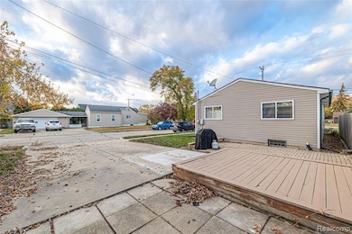 Rear view of property featuring a wooden deck and a patio
