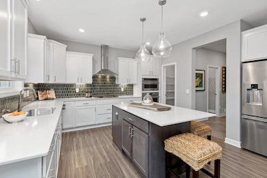 Photo is of the actual home. The spacious gourmet kitchen includes a large center island, quartz countertops, LVP floors, stainless appliances and more!