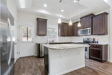 Kitchen featuring dark brown cabinetry, appliance