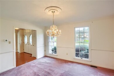 The elegant dining room features a chair rail, ceiling medallion complimenting the chandelier, crown molding and access to the butler's station.