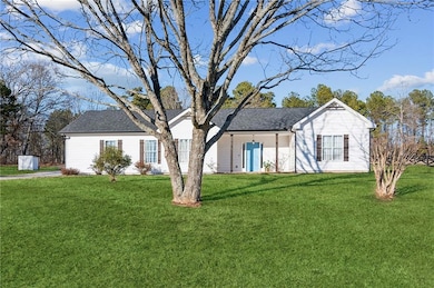 Ranch-style house with a front yard and a shingled roof