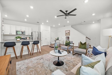 Living area with light wood finished floors, recessed lighting, and a ceiling fan