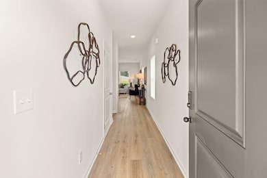 Corridor with light wood finished floors and recessed lighting