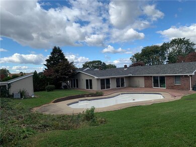 backyard view of home, pool, and utility shed/