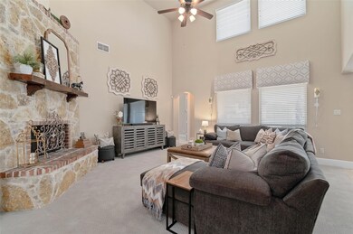 Living area featuring stone fireplace, large windo