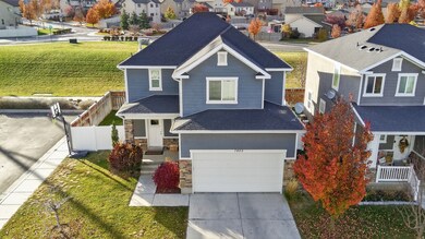View of front of house with stone siding, a residential view, driveway, and a shingled roof
