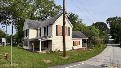 View of side of property featuring a shingled roof, a yard, and covered porch
