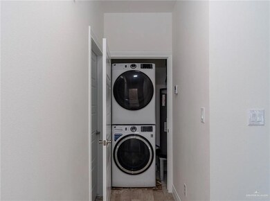 Washroom featuring baseboards, stacked washer / dryer, and laundry area