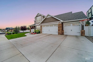 View of front of home featuring driveway, stone siding, an attached garage, and roof with shingles