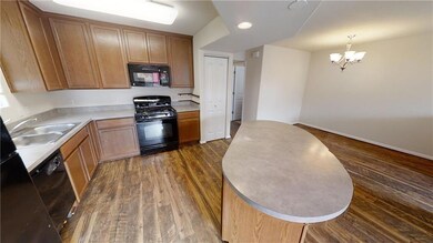 Kitchen featuring a sink, a notable chandelier, l