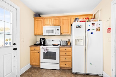Kitchen featuring dark countertops, baseboards, an