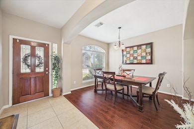 FORMAL DINING AT ENTRY OFFERS WOOD LAMINATE FLOORING AND ELEGANT ARCHES