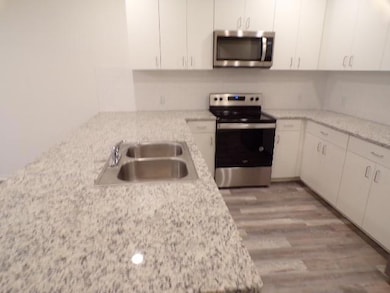 Kitchen with white cabinets, stainless steel appli