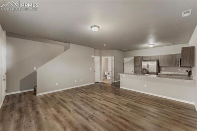 Unfurnished living room with baseboards, dark wood