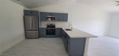 Kitchen with marble finish floor, gray cabinetry,