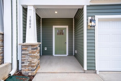 Welcoming covered front stoop with a stone-wrapped