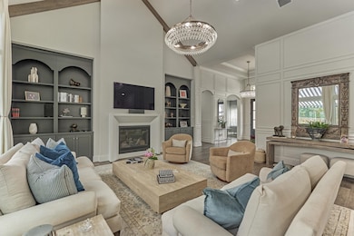 Expansive living area showcasing elegant picture frame molding throughout the hall and extending into multiple rooms, highlighting the home's exquisite craftsmanship.